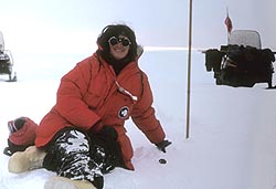 Laurie Leshin sits next to a meteorite in snowy Antarctica