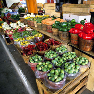 farm direct produce sits in bins and containers in a farmers' market