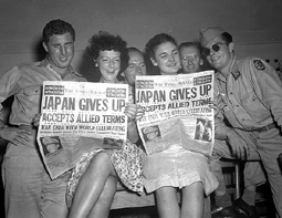 Photo of  US Military Personnel And Civilian Women Reading Newspaper. Head line Reads Japan Gives Up.