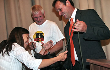 Photo showing Elaine Gin, attorney-advisor in the USPTO Office of Enforcement, meeting dog trainer, Neil Powell (left), and Flo, the Motion Picture Association of America's DVD-sniffing dog.  The MPAA hosted an event in Washington D.C. to launch its new program which uses specially trained dogs to help prevent the import and export of fake DVDs.  A USPTO-sponsored enforcement class from around the world attended the launch.
