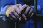 Inmates hands through prison bars