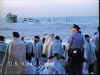 A view of the vessel Golden Venture aground off the beach, with numerous migrants and police ashore.