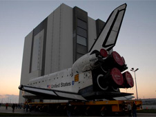 A space shuttle orbiter rolls toward the Vehicle Assembly Building.