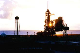 The early morning sun is caught between Space Shuttle Discovery and its external tank on Launch Pad 39A.