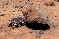 The Sojourner Rover examines a rock on Mars. The rover traveled from Earth aboard the Mars Pathfinder space probe, then rolled down a ramp to the surface. Sojourner is only 24 3/4 inches (63 centimeters) long.