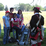 soldier talking to kids about the role of slaves and freedmen in the revolution