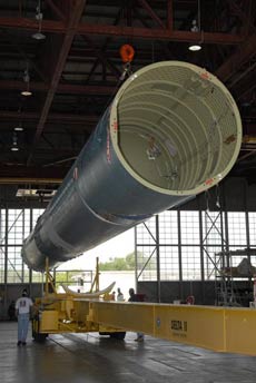 Workers guide a Delta II first stage as it is placed on a trailer.