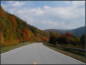 A fall picture along a scenic byway.  The trees along the road are starting to turn brown.