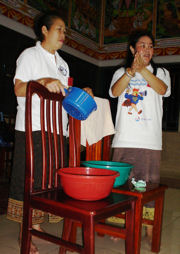 Image of two women from Laos teaching methods to prevent the spread of avian influenza.