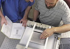 Photo of NIST researchers using Braille reader.  Click here for larger image.