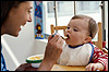 photo of a woman feeding a baby