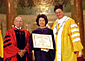 Professor William F. Fox, Dean of the Columbus School of Law (left), and the Very Rev. David M. O'Connell, C.M., President of the Catholic University of America (right), award Secretary Chao with an honorary doctorate.