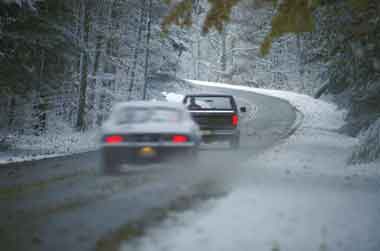 Motorists are traveling on a slush covered rural road after a storm. Using strategically placed environmental sensors along roadways, managers can monitor snowfall and temperatures to determine optimal times and strategies for treatments.