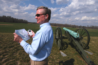 A visitor stands next a cannon overlooking the Malvern Hill battlefield.