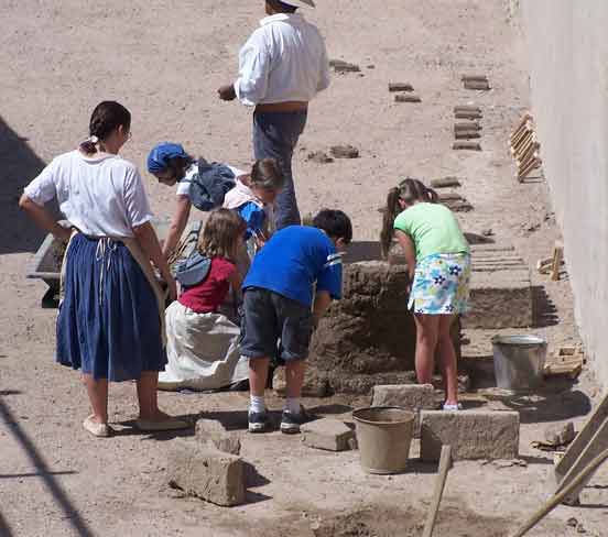 School students making adobe bricks. 