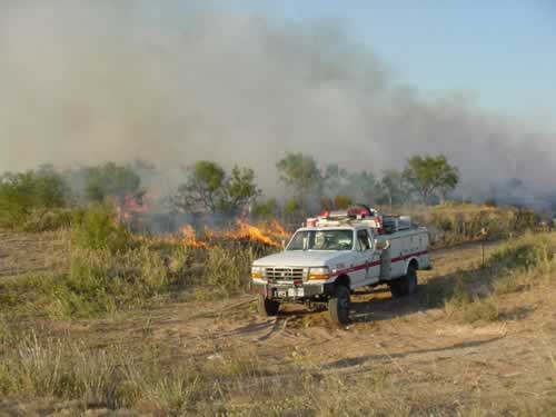 a fire truck near the edge of the burn area