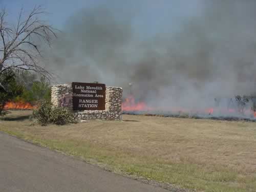 an entrance to Lake Meredith National Recreation Area with fire in the background