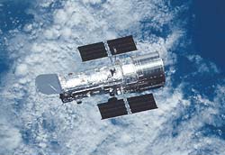 The Hubble Space Telescope, an orbiting observatory launched in 1990, circles Earth high above the atmosphere.