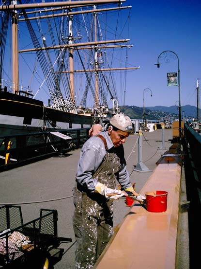 Volunteer Gene Backlund on Hyde Street Pier painting a spar.