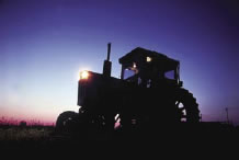 Tractor silhouetted by the sun