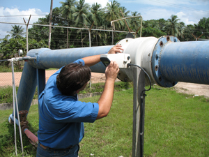 Dr. Monteiro inspects turbidity levels at water treatment facility in Linden, Guyana.