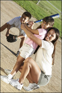Foto: una madre le enseña a su hija a jugar béisbol