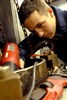 U.S. Navy Seaman Daniel Diem uses a heat gun to remove bits of plastic from a plastic waste processor aboard USS Essex, May 11, 2008. Diem is a boatswain's mate. 