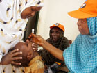 A World Health Organization ,WHO, official gives a dose of Polio Vaccine to Somali child in Mogadishu, Somalia. [AP PhotoSept. 2006]
