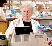 Still image of pharmacist behind cash register from Generic Initiative for Value and Efficiency (GIVE) Video