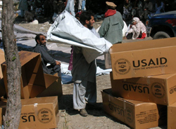 Photo of boxes with USAID logo being unloaded in Pakistan.