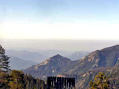 Layers of polluted air hang over the valley beyond a ridge of hills.