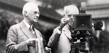 Thomas Edison George Eastman looking at a motion picture camera.