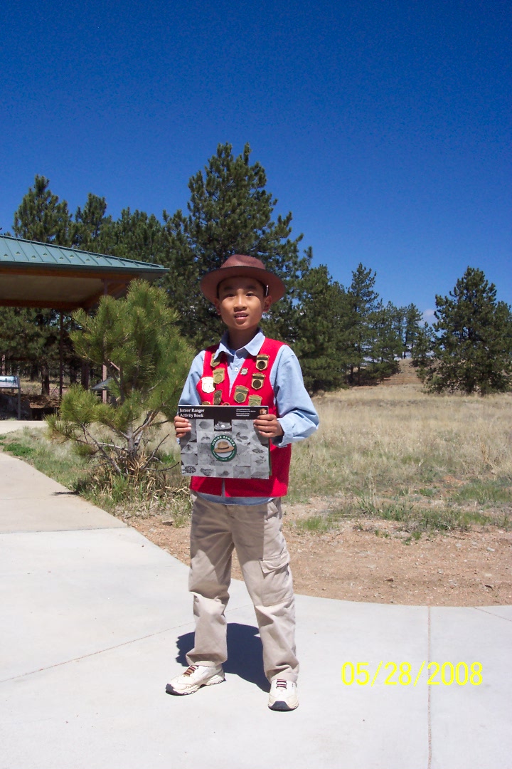 Junior Ranger Andrew wearing his Junior Ranger vest and hat earns his  badge at Florissant. One of many!