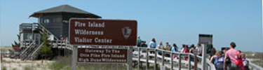 Group of students pass park sign as they walk down boardwalk to the Wilderness Visitor Center.