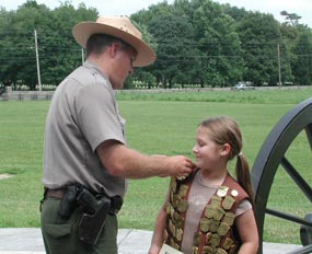 A Junior Ranger receives her badge.