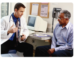 Doctor explaining details of prescription medication to an older African-American patient.
