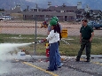 A CERT member and buddy approaching and extinguishing the fire.