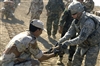 U.S. Army Explosive Ordnance Disposal (E.O.D) team leader 1st Lt. Adam Daino assists soldiers from the 8th division, Iraqi army E.O.D. team with unloading confiscated ordnance that will be destroyed at a demolition range outside of Camp Echo, Iraq, July 4, 2008. 