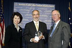 Secretary of Labor Elaine L. Chao (L) and Assistant Secretary of Labor for Disability Employment Policy Roy Grizzard (R) present a 2003 Secretary of Labor's New Freedom Initiative Award to Eric Stevens, CEO, Courage Center. (DOL Photo/Shawn Moore) 