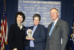 Secretary of Labor Elaine L. Chao (L) and Assistant Secretary of Labor for Disability Employment Policy Roy Grizzard (R) present a 2003 Secretary of Labor's New Freedom Initiative Award to Millie Hewett, Business Development Manager, Manpower, Inc. (DOL Photo/Shawn Moore)