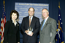 Secretary of Labor Elaine L. Chao (L) and Assistant Secretary of Labor for Disability Employment Policy Roy Grizzard (R) present a 2003 Secretary of Labors New Freedom Initiative Award to Mark Feidler, COO, Cingular Wireless. (DOL Photo/Shawn Moore)
