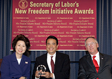 Secretary of Labor Elaine L. Chao (L) and Assistant Secretary of Labor for Disability Employment Policy Roy Grizzard (R) present a 2004 Secretary of Labor's New Freedom Initiative Award to Michael Takemura(c) Director, HP Accessibility Program Office