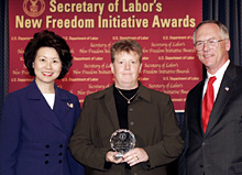 Secretary of Labor Elaine L. Chao (L) and Assistant Secretary of Labor for Disability Employment Policy Roy Grizzard (R) present a 2004 Secretary of Labor's New Freedom Initiative Award to J. Erin Riehle Co-Director, Project SEARCH