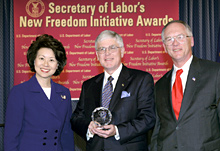Secretary of Labor Elaine L. Chao (L) and Assistant Secretary of Labor for Disability Employment Policy Roy Grizzard (R) present a 2004 Secretary of Labor's New Freedom Initiative Award to Victor P. Manning President & Executive Director MBNA Foundation
