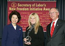 Secretary of Labor Elaine L. Chao (L) and Assistant Secretary of Labor for Disability Employment Policy Roy Grizzard (R) present a 2004 Secretary of Labor's New Freedom Initiative Award to Christy Russell, Director Projects With Industry Salt Lake Community College