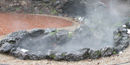 The Lamar Spring and collection pool, with brick walkway surrounding, with steam rising above.