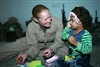 U.S. Marine Corps Cpl. Rebekah D. Hall entertains a young girl as the child’s mother reviews search procedures as part of Sisters of Ferris training, June 5, 2008. Hall is assigned to Combat Logistics Battalion 1, 1st Marine Logistics Group.

