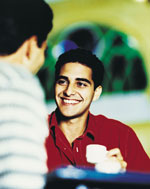 Image of two young Hispanic men having coffee.