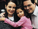 Image of Hispanic mother and father holding small girl.