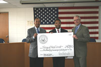 Mayor Robert Donaldson, Congressman Jackson, and Village Manager Robert Palmer holding giant check for $140,855